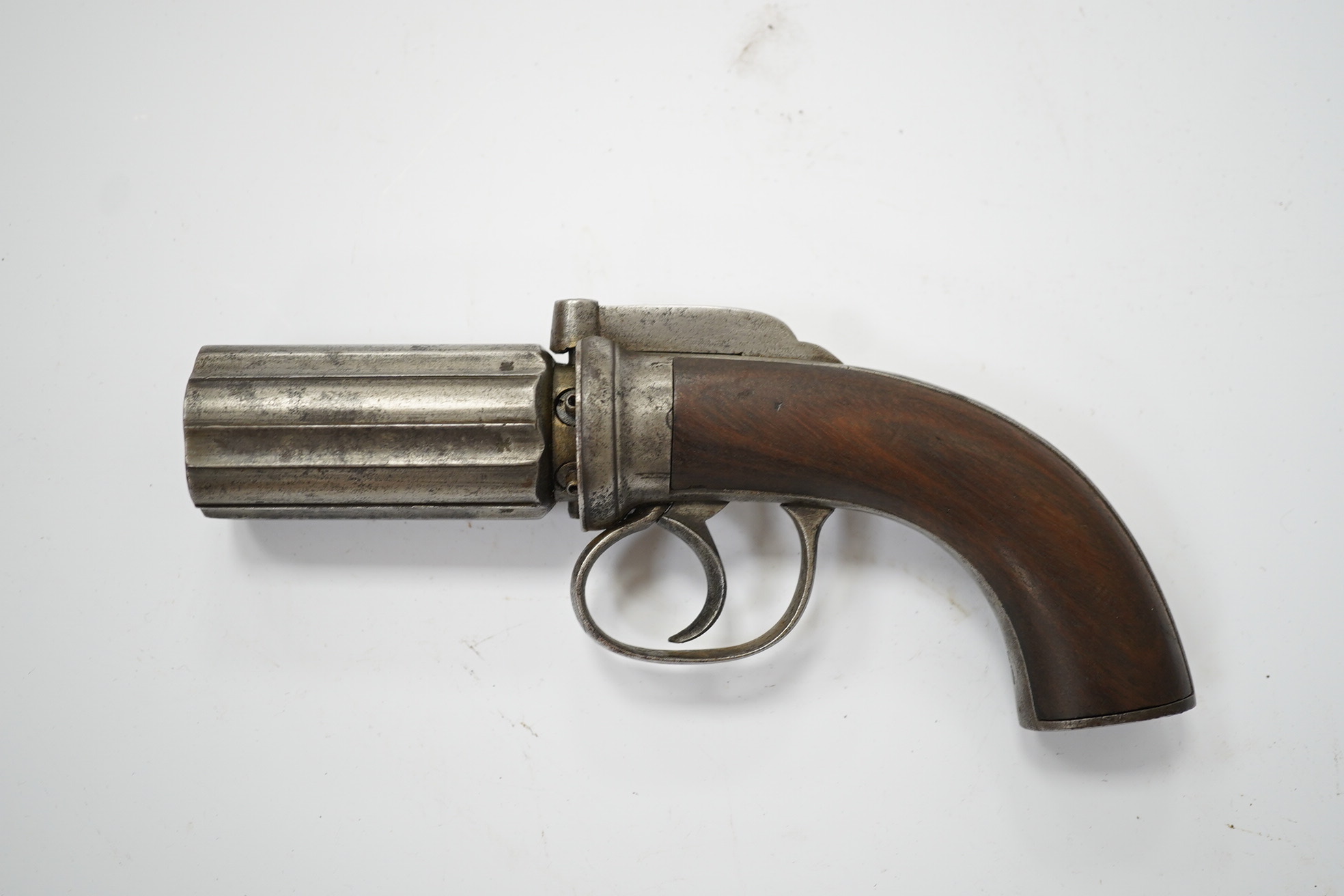 A six shot self-cocking percussion pepper box revolver, with fluted barrels, Birmingham proofed, round frame, and scroll engraved wooden grips, barrel 6.5cm. Condition - fair, alterations to the frame and grip.